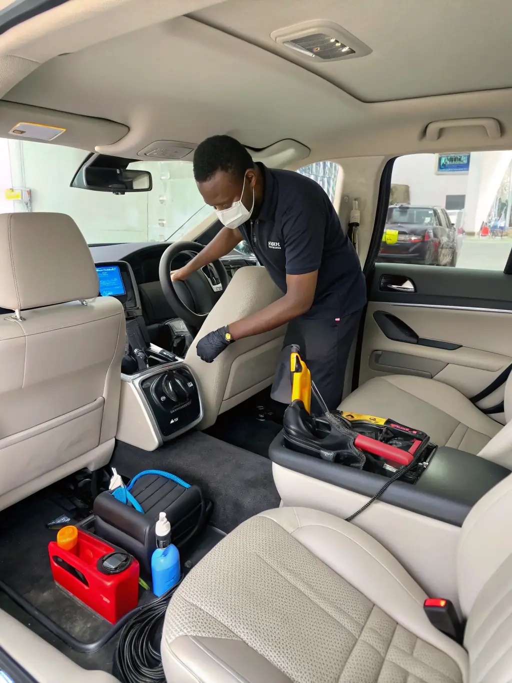 A car undergoing a thorough interior detailing process inside the mobile workshop, showcasing the cleaning and restoration.